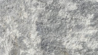 Mermer desenli gri kaya oluşumu. Gri desenli kaya oluşumunun yakın görüntüsü. Yüzey düzensizdir ve oyuklar, çıkıntılar ve küçük çöküntüler gibi çeşitli desenler içerir.. 