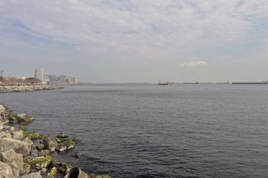 İstanbul, Türkiye. 2 Mart 2025. Güneşli bir günde Bakrky ilçesinden Zeytinburnu ilçesine kadar modern binaları, yürüyüş yolları ve parklarıyla Marmara Denizi manzarası.