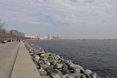 İstanbul, Türkiye. 2 Mart 2025. Güneşli bir günde Bakrky ilçesinden Zeytinburnu ilçesine kadar modern binaları, yürüyüş yolları ve parklarıyla Marmara Denizi manzarası.