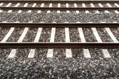 HorizoN.a giden demiryolu rayları. Uzağa uzanan çoklu demiryolu raylarının manzaralı görüntüsü, simetri, yapı ve yolculuğun özünü vurguluyor. Görüntü, hassas mühendisliği vurguluyor ve bir yolculuk hissi uyandırıyor. 