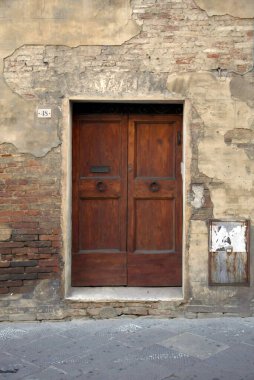 Evin duvarındaki eski ahşap kapı. Kavramsal görüntü. Eski Ev Duvarındaki Tahta Kapı. Mimari Detaylar Zamanla Aşındı ve Yıprandı. Solmuş duvar boyası, zamanın ve terk edilmenin etkilerini gösterir.. 