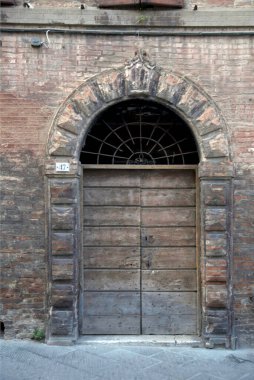 Evin duvarındaki eski ahşap kapı. Kavramsal görüntü. Eski Ev Duvarındaki Tahta Kapı. Mimari Detaylar Zamanla Aşındı ve Yıprandı. Solmuş duvar boyası, zamanın ve terk edilmenin etkilerini gösterir.. 