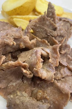 Doner Kebap Lezzetli Sulu et dilimleri, çıtır patates dilimleri, aroma, doku ve otantik Türk sokak yiyecekleri cazibesinin mükemmel uyumu..