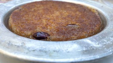 Pistachio ile otantik Türk Bıçak Tatlısı. Geleneksel Ortadoğu Kunafa tatlısına yakın plan. Eritilmiş peynirli gevrek kadayf hamur işi, tatlı şuruba batırılmış ve metal bir tabakta sıcak servis edilmiş..