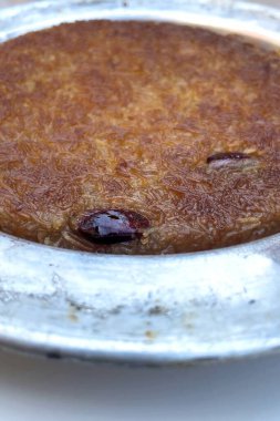 Pistachio ile otantik Türk Bıçak Tatlısı. Geleneksel Ortadoğu Kunafa tatlısına yakın plan. Eritilmiş peynirli gevrek kadayf hamur işi, tatlı şuruba batırılmış ve metal bir tabakta sıcak servis edilmiş..