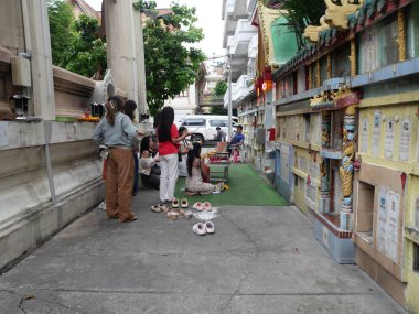 Wat Khanikaphon, Çin Mahallesi, Bangkok, Tayland. 3 Mayıs 2025. İnsanlar duvardaki mezarlara saygılarını sunuyorlar..