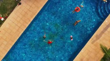 İnsanlar dinlenme yerlerinde dinlenirken dinlenme havuzunda eğlenmeyi seviyorlar. İnsansız hava aracı, manzaralı bölgeler ve çevresindeki binalarla birlikte tüm tatil ortamını gözler önüne seriyor.