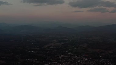 Soluk maviden yumuşak şeftaliye karışan bir gökyüzü ile sakin bir alacakaranlık sahnesi. Vadide bir köy var, tarlaların ortasında, sisli tepelere giden yollarla bağlı, huzuru ve doğal güzelliği çağrıştıran..