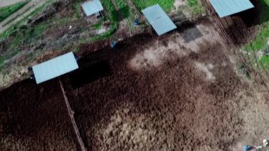 İnsansız hava aracı, yabani otlakların üzerinden binicilerle dolu bir sahil merkezine uçar, sonra sakin bir sahil, yemyeşil bahçeler ve parçalı bulutlu gökyüzü altında bir oyun alanı yakalar, doğa ve insan harmanlayan doğa ve insan.