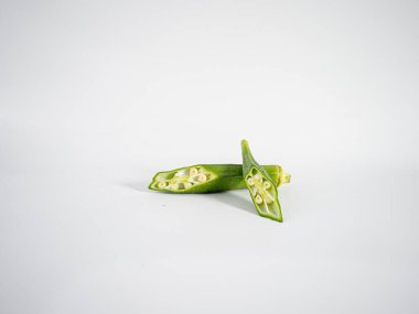 Parlak bir bamya diliminin makro görüntüsü temiz tohum düzeni gösteriyor. Tayland mutfağı, otlar ya da bitki bazlı gıdalar için mükemmel bir tema..