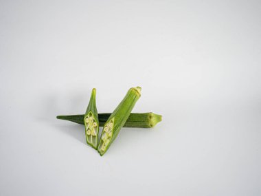 İç tohum desenini ortaya çıkarmak için kesilen bamyanın minimalist fotoğrafı. Sağlık merkezli bileşenlerin temiz ve keskin bir temsili.