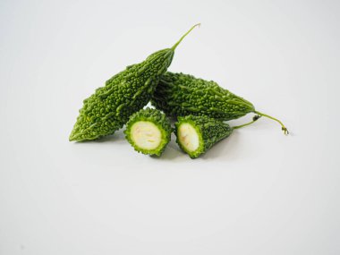 Acı kavun parçalarını, aşçılık ve bitkisel malzemelerin kullanılması için bembeyaz yüzeyde meyve bölümünün yanına yerleştirilmiş tohumlarla kes.