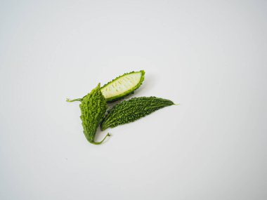 Sade arka planda bir çift acı kabak, sağlık ve vejetaryen ürün temalarını vurguluyor.