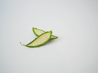 Acı kavun, iç tohum desenini göstermek için uzunlamasına kesilmiş, organik gıda pazarlamasında veya Asya bitki rehberlerinde kullanılması için pürüzsüz beyaz zemin üzerine izole edilmiş