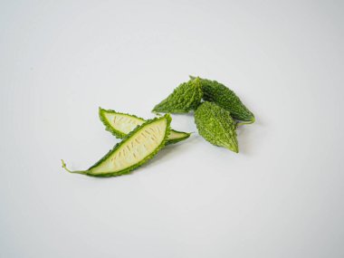 Organik gıda düzeni ve bitkisel temalı tasarım için sanatsal olarak düzenlenmiş üç acı kabak dilimi.