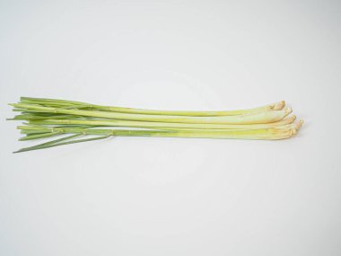 Taze limon otları düzenli bir demet halinde dizilmiş, kökleri görünür, stüdyo ışıkları altında yakalanmış. Tayland mutfağı içeriği, bitkisel tedavi blogları veya diyet ürünü görselleri için ideal.