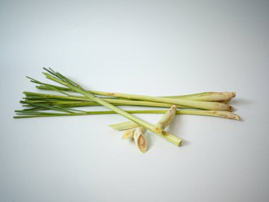 Bir grup limon otu, yelpaze gibi dizilmiş, saplarını ve yapraklarını gösteriyor. Mutfak blogu grafikleri veya bitkisel temalı editör tasarımları için temiz sunulmuştur.