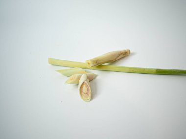 Limon otunun tek bir gövdesi, yemek pişirme, gıda tasarımı veya bitkisel ürün markalaşması için yumuşak beyaz ışığın altında çekilen dilimlerle ikiye ayrılır..