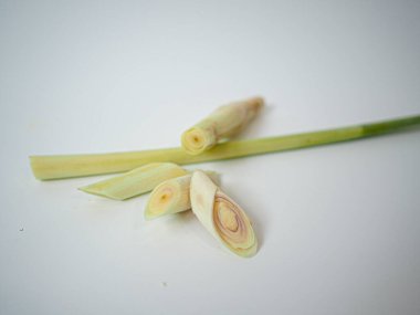 İki tutam limon otu net bir konumda ve çapraz kesikle gösteriliyor. Minimalist beyaz stüdyoda organik malzeme görselleri için yakalandı..