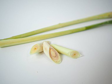 Kesilmiş saplı üçgen düzeninde düzenlenmiş üç dilim limon otundan oluşan temiz bir kompozisyon. Sağlık veya gıda paketleme tasarımı için ideal.