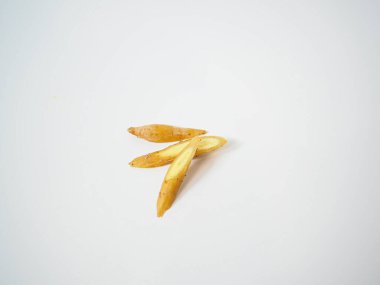 Altın tonu ve bitkisel şekli vurgulamak için çapraz gösterilen dilimlenmiş parmak kökü parçaları.