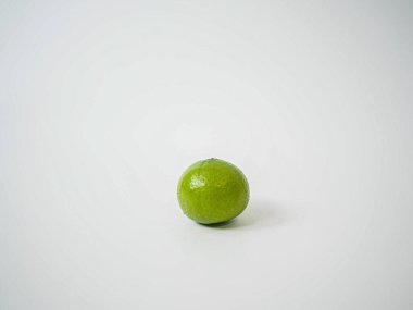 Basit ürün modellemeleri ya da malzeme katalogları için beyaz zemin üzerinde, orta çerçevede yumuşak yayılmış ışık altında tek kireç yakalanır