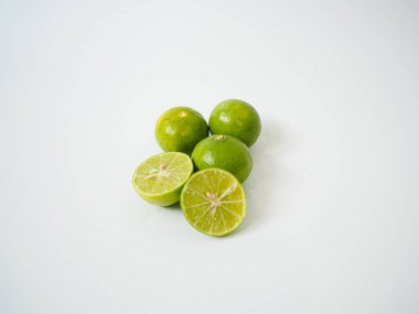 Üç misket limonunun minimalist kompozisyonu ve bir dilim dilimlenmiş gıda tasarım projeleri için temiz beyaz arka plan