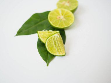 Kireç ve yeşil yaprağın tepesinde doğal yemek pişirme ve detoks promosyonları için taze narenciyeyi temsil eden yeşil yapraklar.