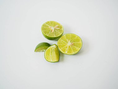 Yapraklı garnitürlü yeşil limon ve yarım dilimlenmiş detaylar yemek menüsü tasarımları ve mutfak ortamında tropikal malzeme markalaşması için mükemmel.