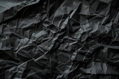 Buruşmuş siyah kâğıt görüntüsü yakın çekim. Arkaplan kullanımı için doku