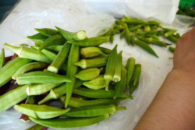 housewife extracting okra, extracting okra for cooking,