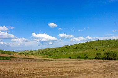 Bulutlu gökyüzü ve yeşil manzara, harika bahar manzarası, yeşil tarla ve tepe manzarası,