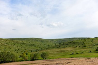 Bulutlu gökyüzü ve yeşil manzara, harika bahar manzarası, yeşil tarla ve tepe manzarası,