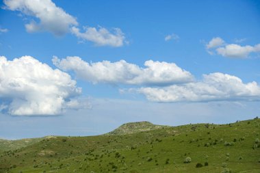 Bulutlu gökyüzü ve yeşil manzara, harika bahar manzarası, yeşil tarla ve tepe manzarası,