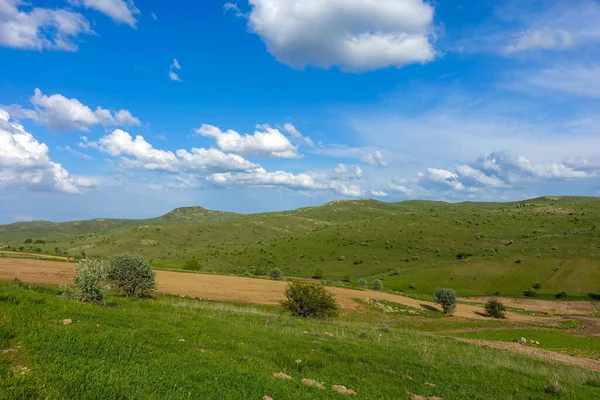 曇り空と緑の風景素晴らしい春の景色緑のフィールドと丘の高原の景色 — ストック写真