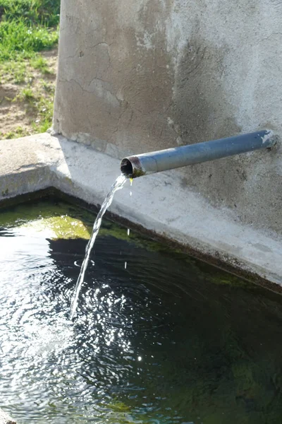パイプから流れる飲料水の泉の閉まり噴水からの澄んだ水の流れ — ストック写真