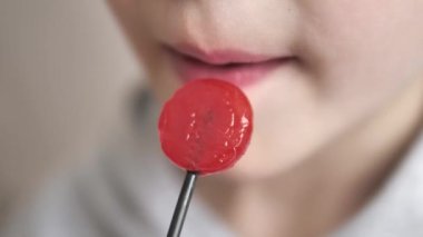 Aç bir çocuk şeker yalıyor,