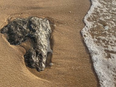 Sahilde kayalar ve beyaz köpük dalgaları