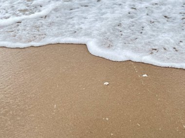 Dalgalarda kum ve beyaz köpük