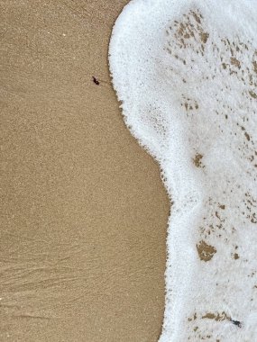 Dalgalarda kum ve beyaz köpük