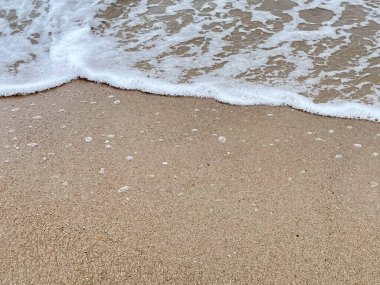 Dalgalarda kum ve beyaz köpük