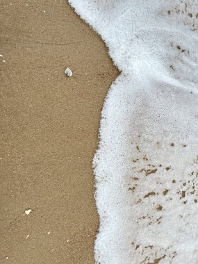 Dalgalarda kum ve beyaz köpük