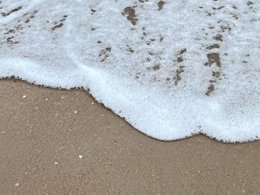 Dalgalarda kum ve beyaz köpük