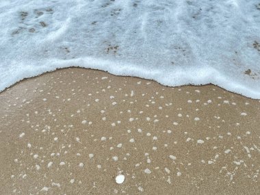 Dalgalarda kum ve beyaz köpük