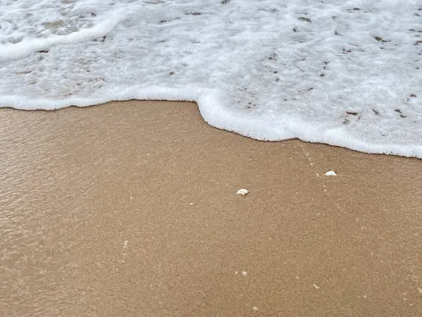 Dalgalarda kum ve beyaz köpük