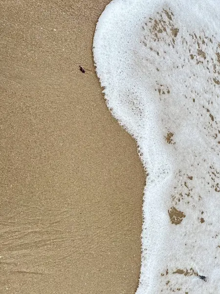 Dalgalarda kum ve beyaz köpük