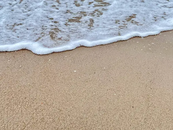 Dalgalarda kum ve beyaz köpük