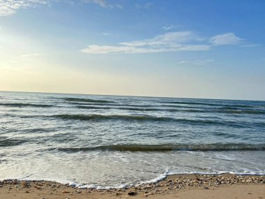 Deniz, kum, sabah güneşi. 