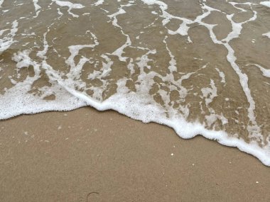  Kum zemininde beyaz köpük dalgalarının yakın plan görüntüsü