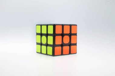 Rubik küp bulmacası meraklıları yeşil ve turuncu renkli parlak neon çıkartmaları, beyin eğitimi, beyin, en popüler yapboz oyuncakları, mantık hafızası, ergonomik tasarım için, beyaz arka planda izole edilmiş beyin eğitimi sorunları çözme egzersizlerine yardım ediyorlar.